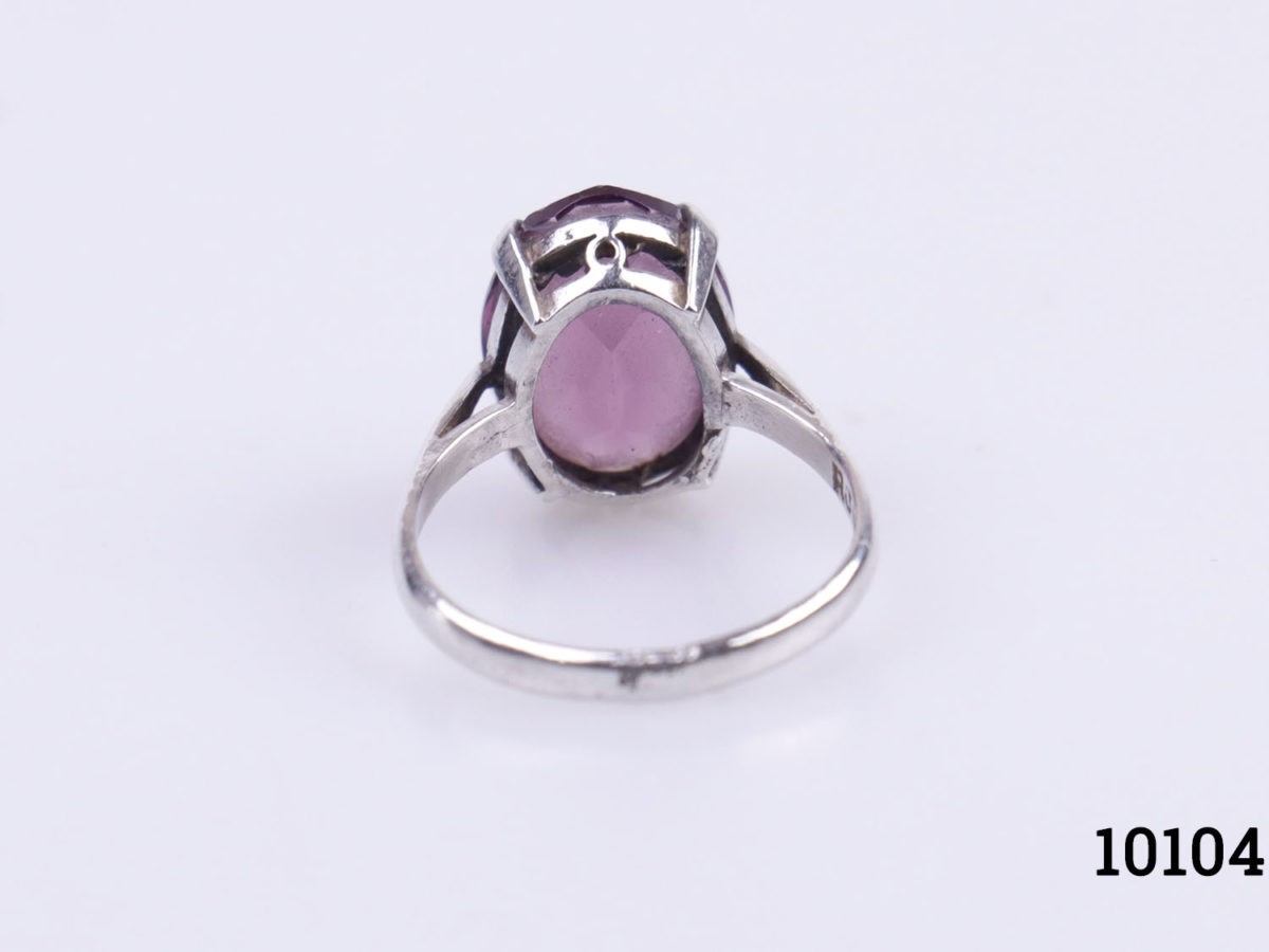 Vintage sterling silver ring with oval cut amethyst stone. c1975 Birmingham assayed. Ring size L.5 / 6 Photo of ring on a flat surface seen from the back showing the under gallery