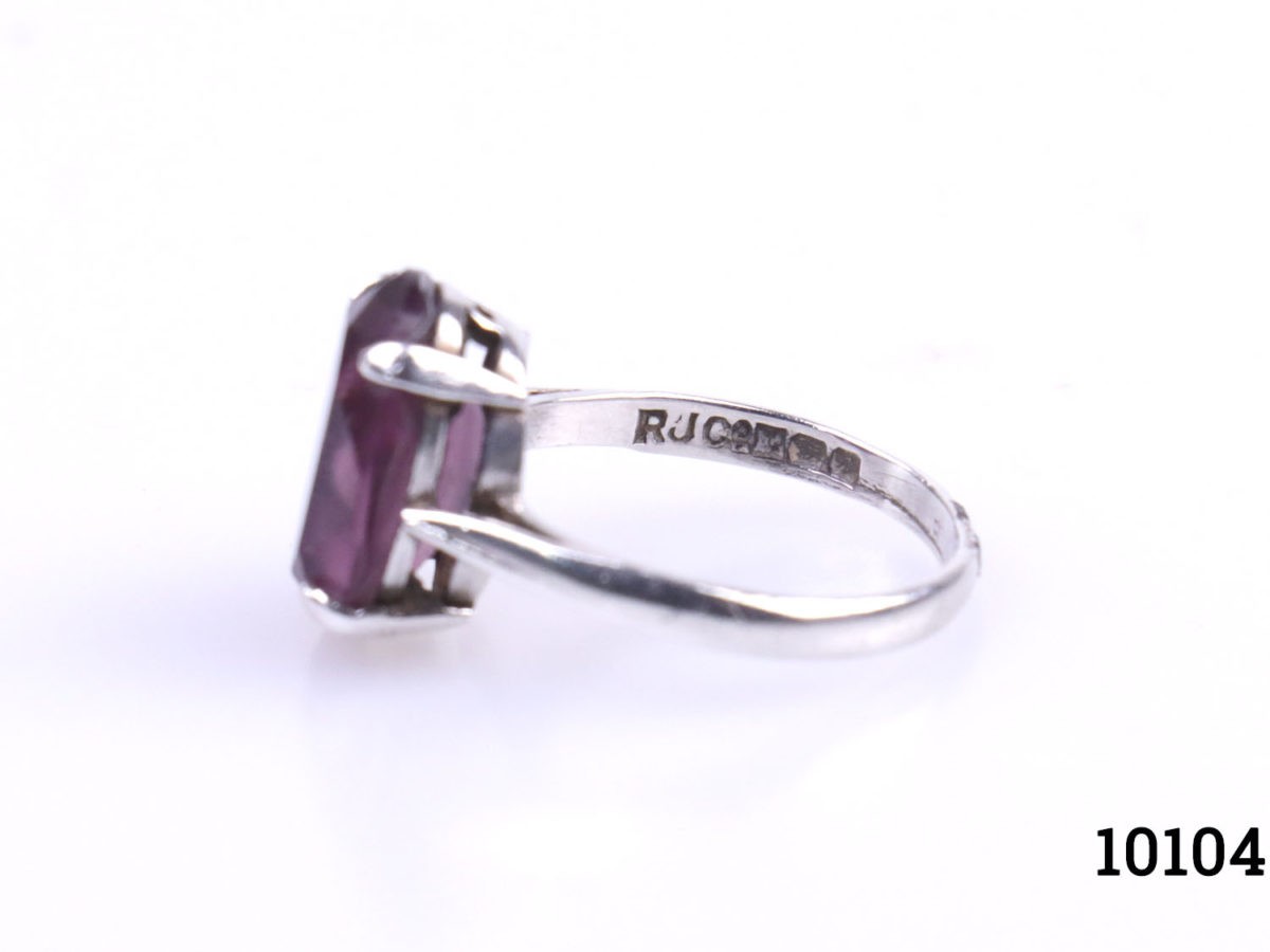 Vintage sterling silver ring with oval cut amethyst stone. c1975 Birmingham assayed. Ring size L.5 / 6 Photo of ring on a flat surface seen with amethyst stone facing left and hallmark on inner band visible