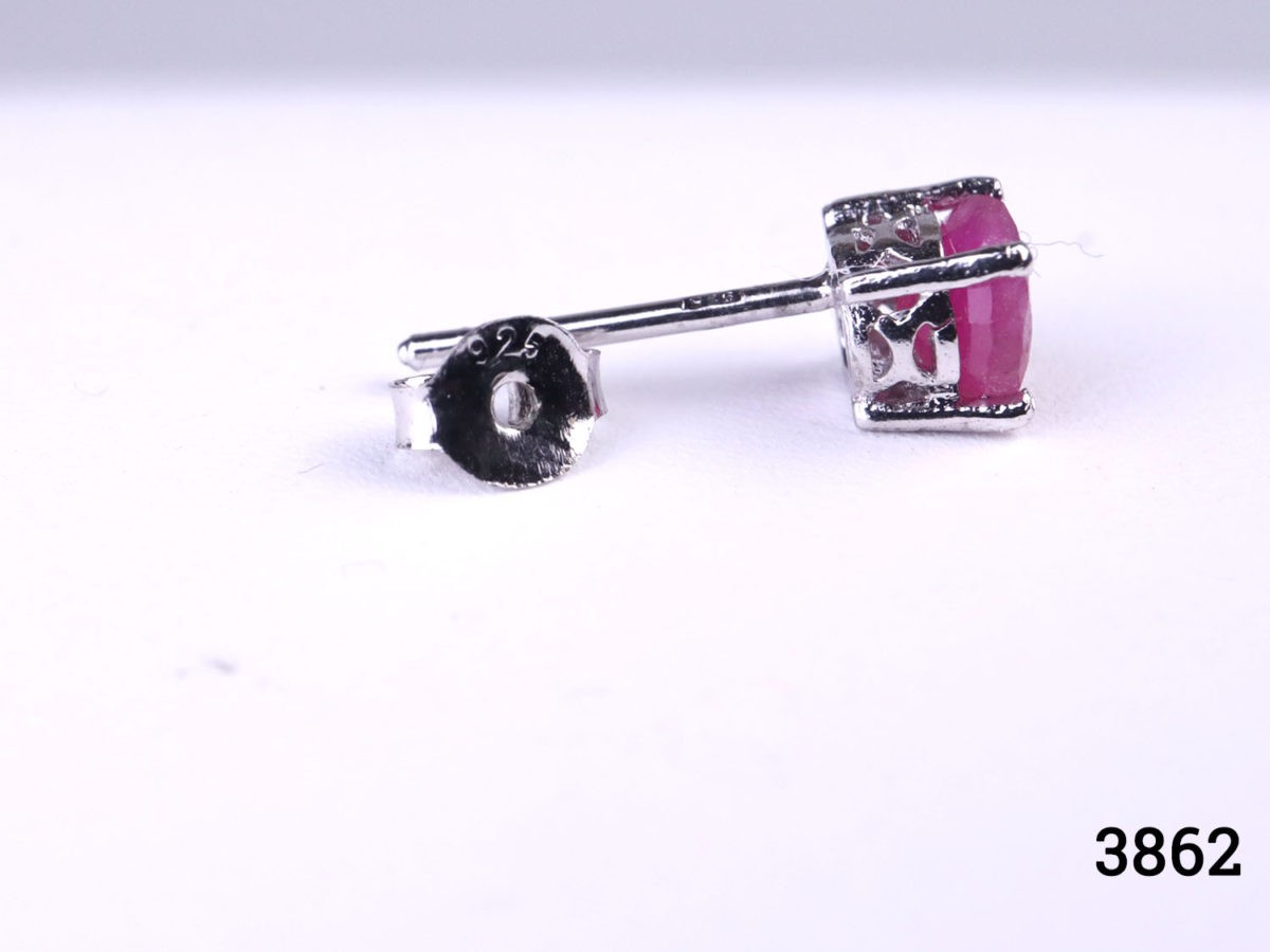 Modern sterling silver stud earrings set with round cut cloudy ruby stones to each. Hallmarked 925 for sterling silver. Earrings weight 1.4 grams. Box included. Photo of one earring with the butterfly fastener remov ed and showing the 925 sterling silver hallmark on both butterfly and stem of earring