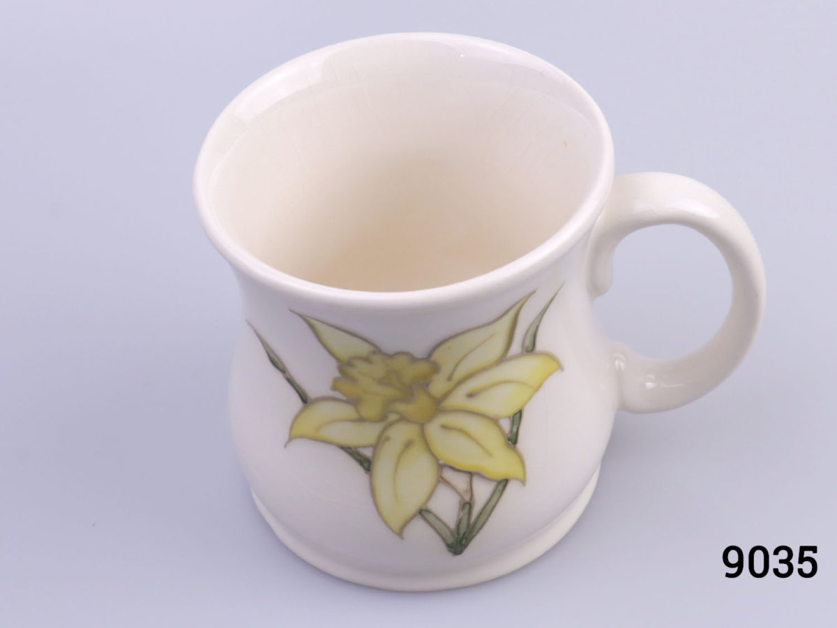 Vintage Moorcroft mug in daffodil pattern. Impressed Moorcroft mark to the base. c1980s. Measures 80mm in diameter at base Photo looking at mug from above looking slightly into inside