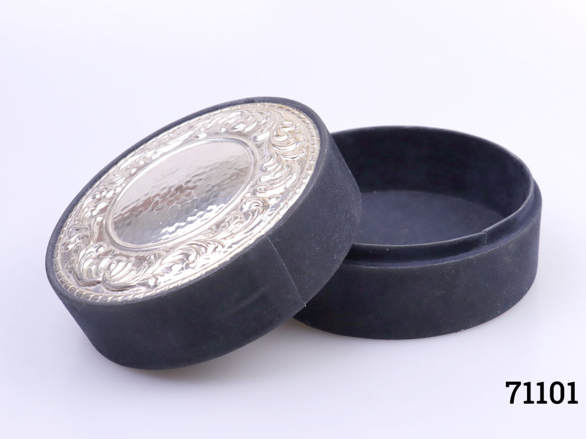 Vintage navy blue velvet covered circular box with a sterling silver disc to the top.Embossed scrollwork around the edge of the disc. Hallmarked on the outside edge of disc. Measures 115mm in diameter. Photo of box with lid removed and leaning up on the side