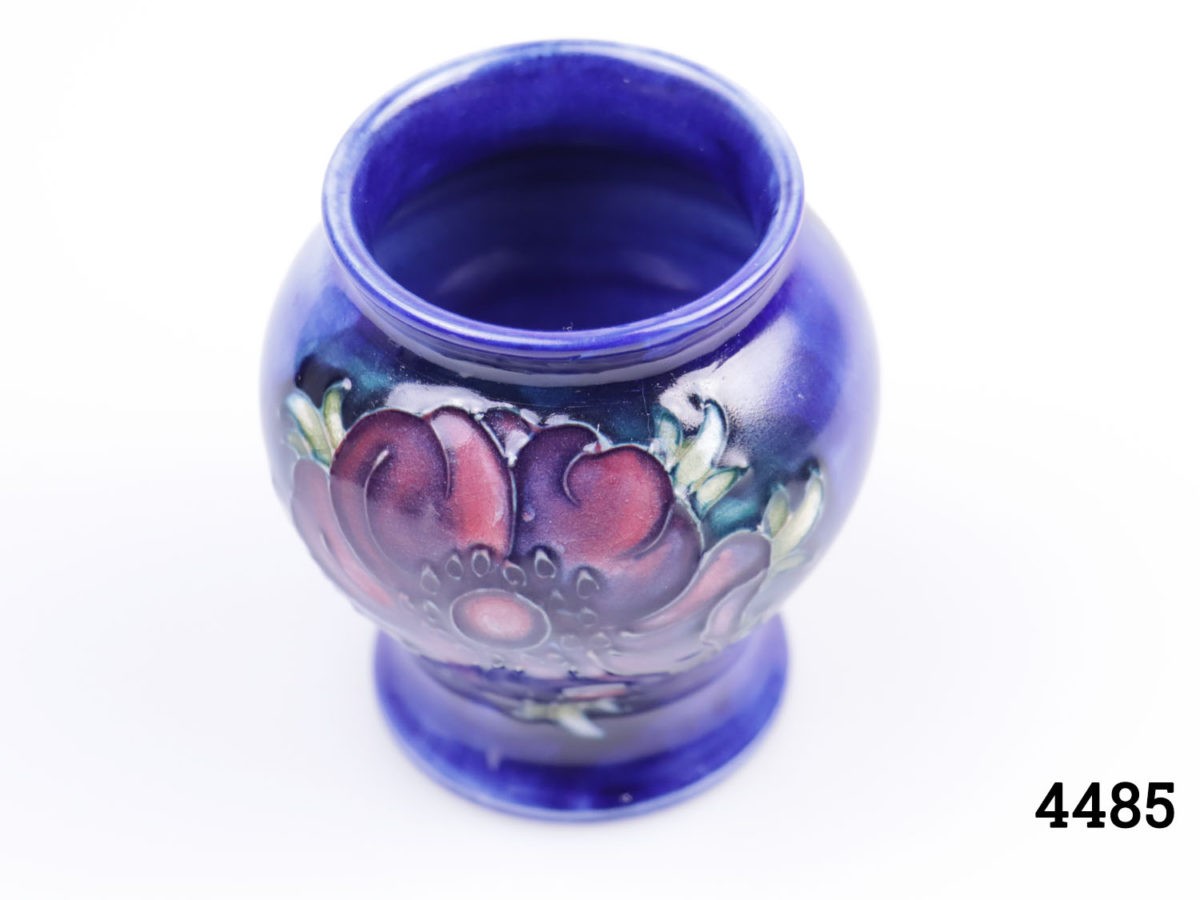 Small Moorcroft pin dish in cobalt blue with buttercup design. Measures 120mm in diameter. Photo of vase looking from a slight raised height partially showing interior