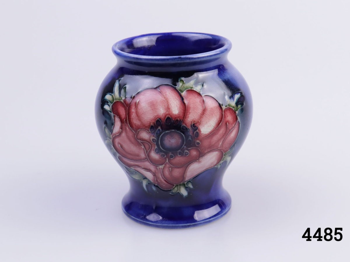 Small Moorcroft pin dish in cobalt blue with buttercup design. Measures 120mm in diameter. Close up photo of vase showing the lighter maroon coloured anemone side