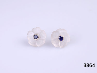 18 karat gold flower stud earrings with a round cut sapphire to the centre of carved crystal flower form. The crystal flower part can be removed and the sapphire studs worn independently. Flower measures 15mm in diameter. Earrings weight 4.5 grams. Main photo of both earrings on a flat surface seen from the front