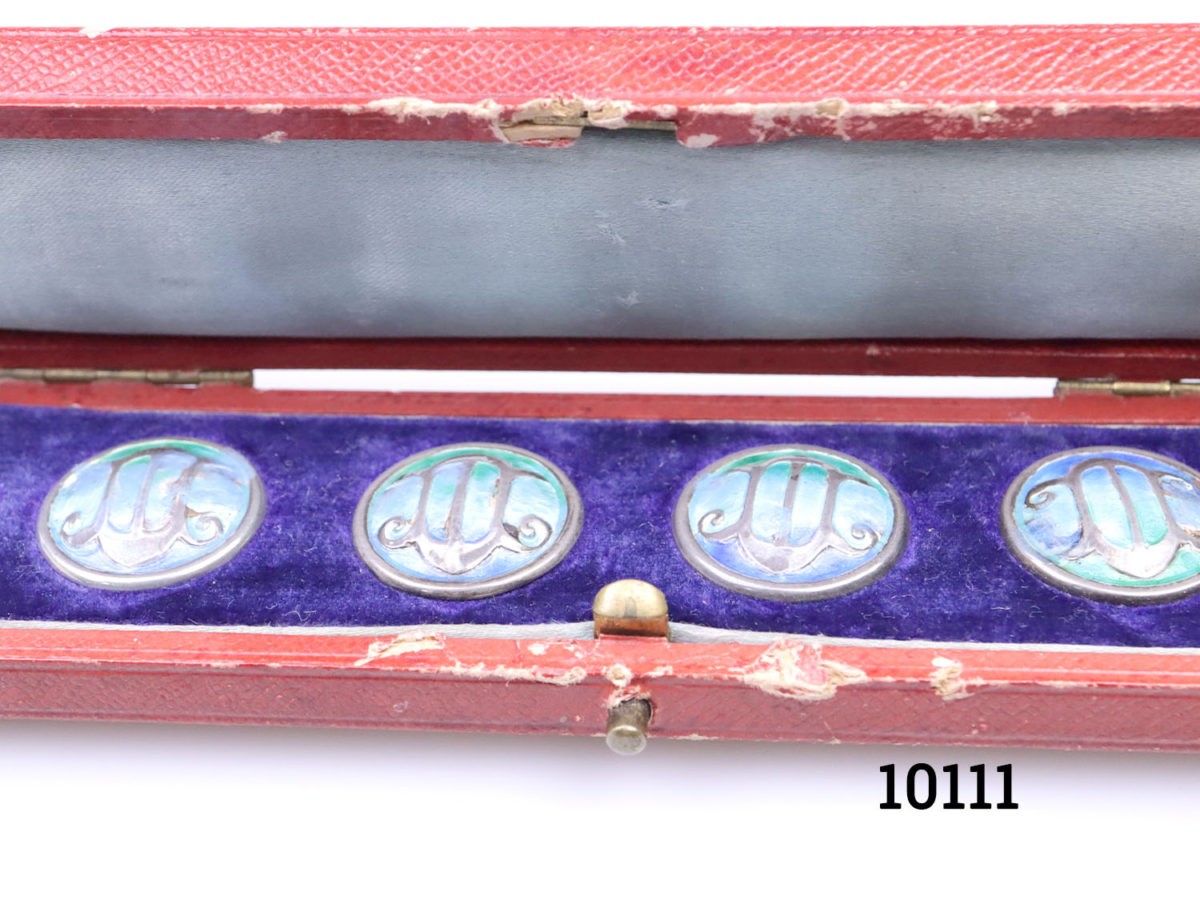 Antique boxed set of Art Nouveau buttons. 6 silver buttons with enamel decoration to each front. Original case.(some wear) Each button weighs 2.7g and measures 20mm in diameter Close up of the buttons to the centre inside the box showing the wear to the case