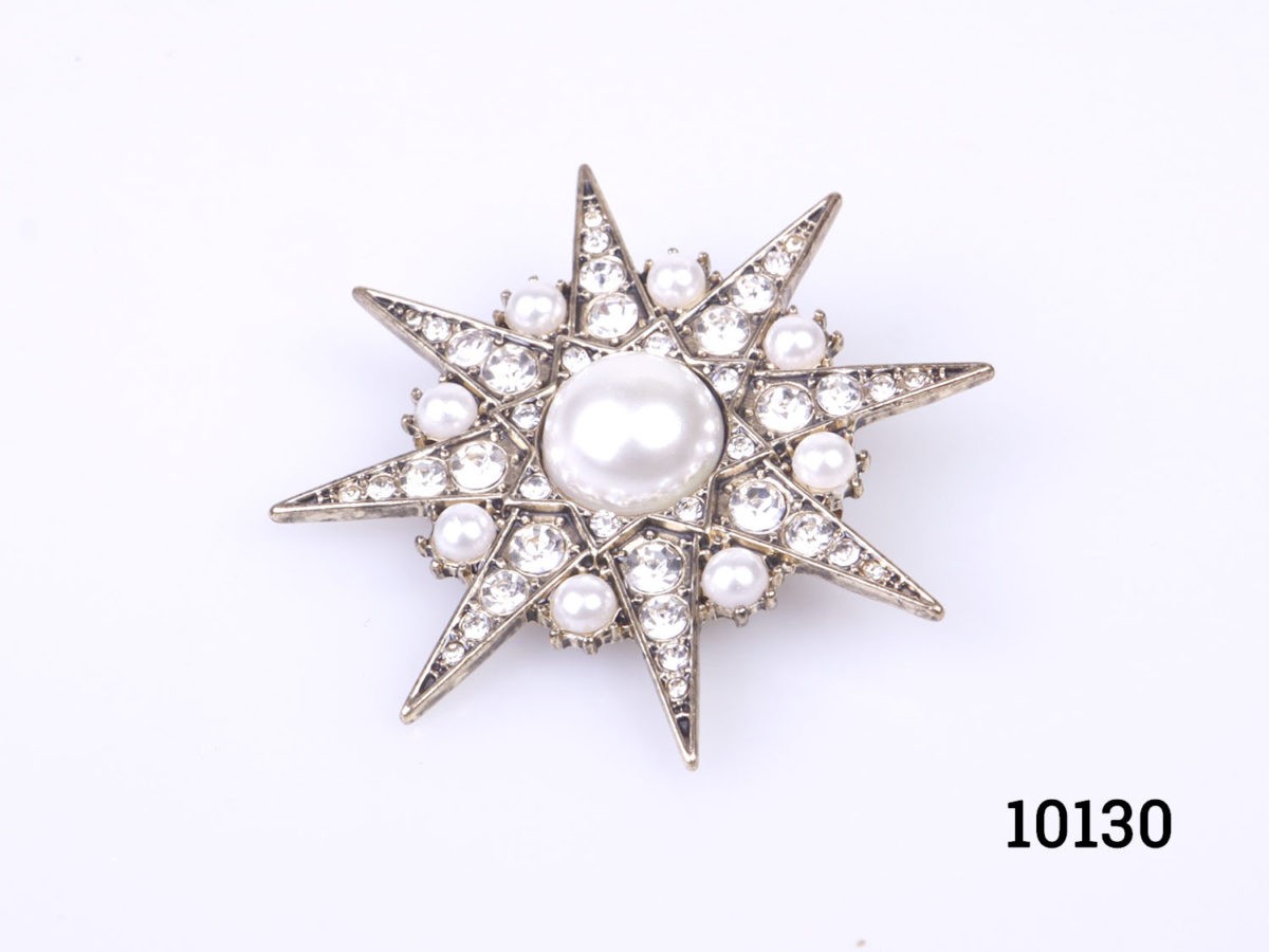 Vintage costume jewellery faux pearl and crystal encrusted 8 sided star brooch set on gilt metal. Measures 48mm in diameter. Photo of brooch front set slightly at an angle