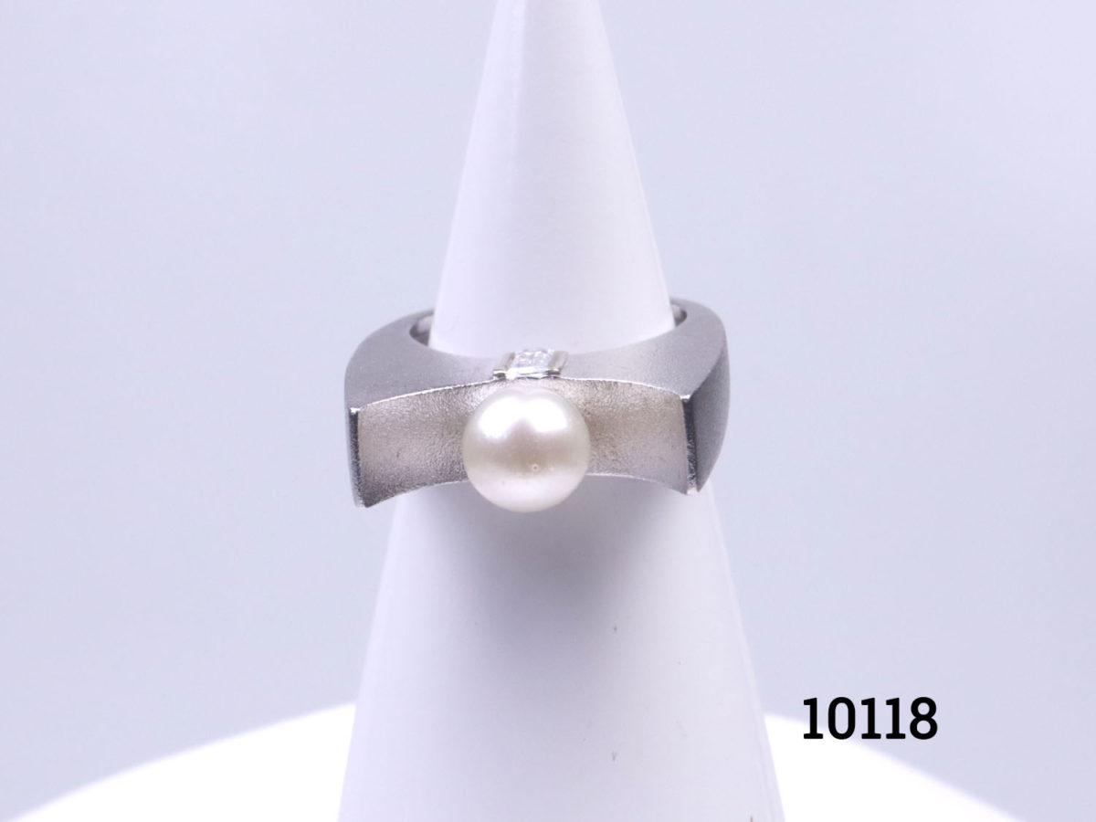 Chunky Modernist style sterling silver ring set with pearl to the centre and cubic zirconia to the sides below the pearl. Ring size P / 7.5. Ring weight 11.9 Main photo of ring displayed on a stand and seen from the front