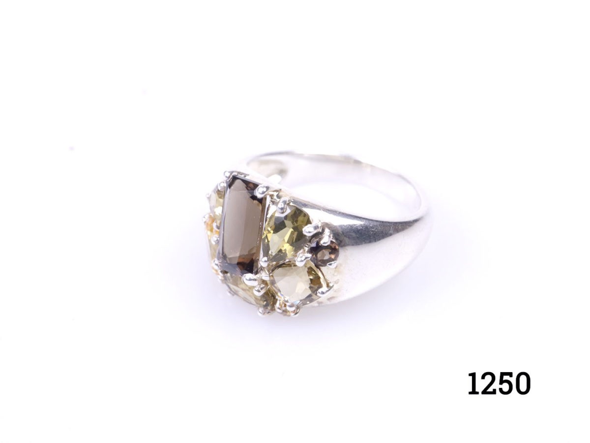 Modern 925 sterling silver ring set with a cluster of multiple shape cut smoky topaz and citrine stones. Hallmarked 925 for sterling silver. Size M / 6.25 Photo of ring on a flat surface shown from a slight angle to the side
