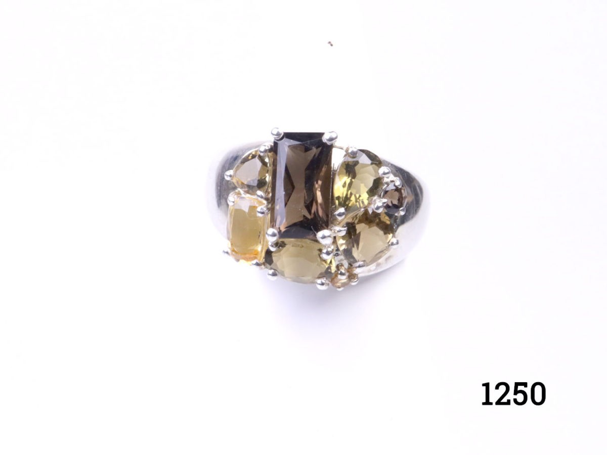 Modern 925 sterling silver ring set with a cluster of multiple shape cut smoky topaz and citrine stones. Hallmarked 925 for sterling silver. Size M / 6.25 Main photo of ring displayed on a stand and seen from the front