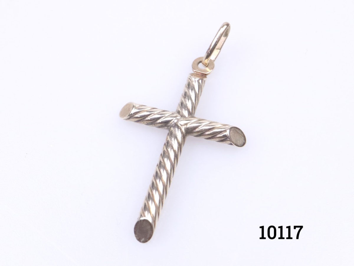 Vintage 9 karat gold cross in a rope twist design. Fully hallmarked to the bail for imported gold assay stamped in Sheffield and on the top of the cross. c1975-1998. Drop length 40mm Close up photo of cross on a flat surface at a slight diagonal angle to the left