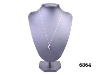 Vintage 9 karat gold fine necklace with a small 9 karat gold pendant set with oval cut amethyst stone. Pendant drop length 16mm Necklace chain length 500mm. Weight of chain and pendant 2.8 grams Main photo showing necklace on a display stand and seen from the front