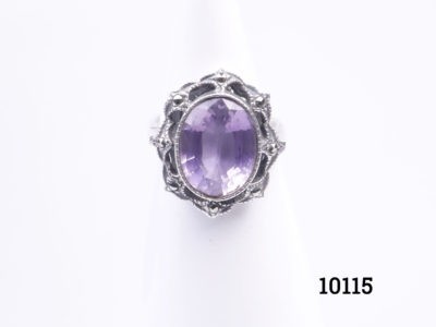Vintage sterling silver ring set with a dark lilac coloured oval cut amethyst. Ring size N / 6.5. Ring Weight 5.5g Main photo of ring displayed on a stand and seen from the front
