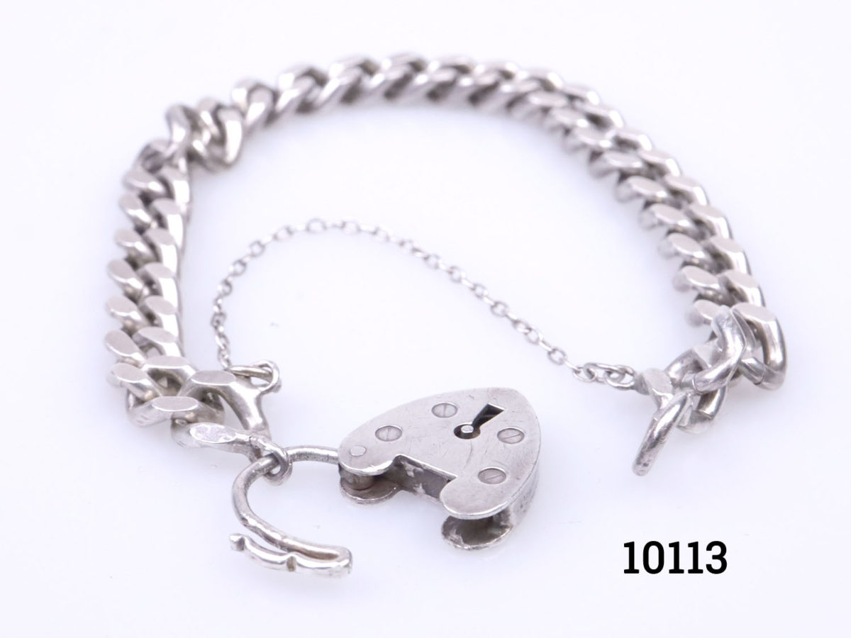 Vintage chunky sterling silver curb chain bracelet with heart shaped lock.Lion passant hallmark on one link and no hallmark on the lock. Safety chain extends opening. Lock has some signs of wear but fully functional. Photo of bracelet with heart lock open and safety chain partially extended open