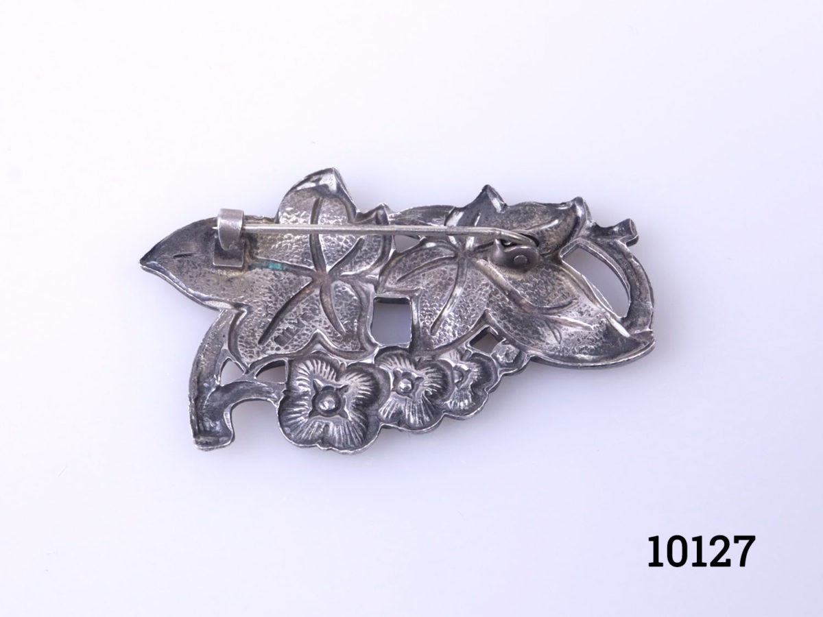 Vintage silver brooch with enamelled floral frontage. Hallmarked silver to the back. Photo of back of brooch