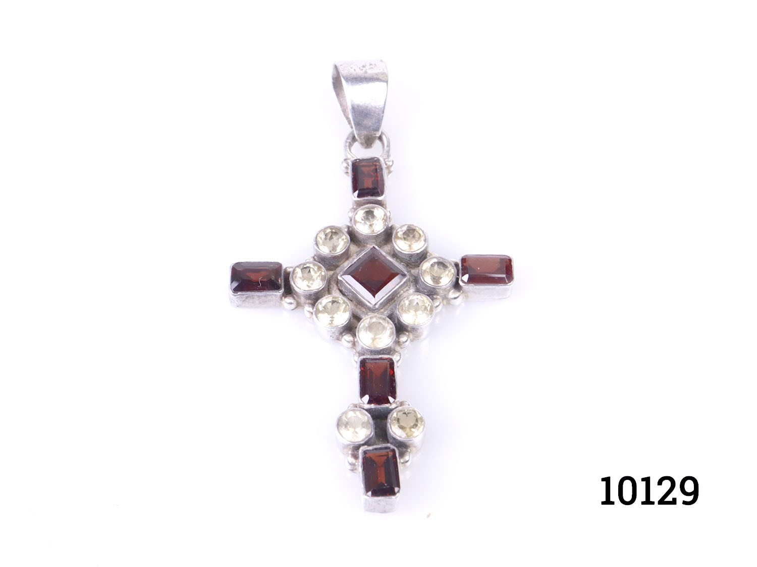 Vintage silver cross encrusted with oval cut wine red garnets and round cut pale lemon citrine stones. No hallmarks but tests for sterling silver. Main photo of cross pendant on a flat surface with pendant bail to the top centre of picture