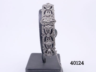 Vintage Sterling silver and marcasite bracelet. Vintage marcasite encrusted hinged bracelet with box clasp fastening and safety chain. Bracelet opening when fully open 45mm When closed 55mm by 50mm Main photo of bracelet displayed on a stand and seen with marcasite side to the foreground
