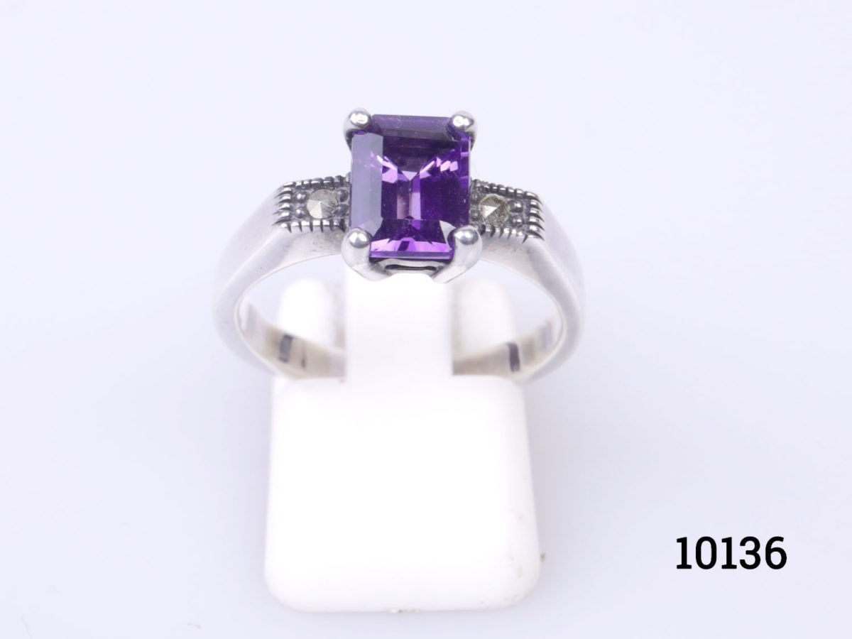 Vintage 925 sterling silver ring set with rectangle cut amethyst coloured purple crystal to the centre. Ring size P / 7.5 Photo of ring displayed on a short ring display stand with ring front facing slightly upward towards the lights