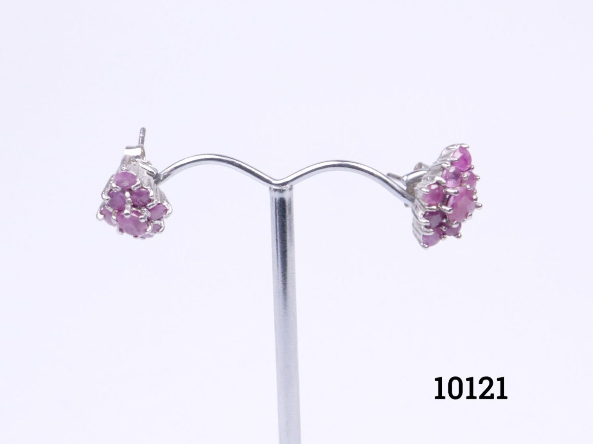 Vintage sterling silver earrings encrusted with rubies Each earring front measures 15mm by 8mm. Earrings weigh 4.7grammes Photo of earrings on a display stand