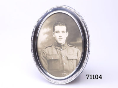 c1995 small sterling silver oval frame. Fully hallmarked for Sheffield assay to the side of the frame. Made by Carr's. Main photo of photo frame front. (Shows black & white picture print of soldier)