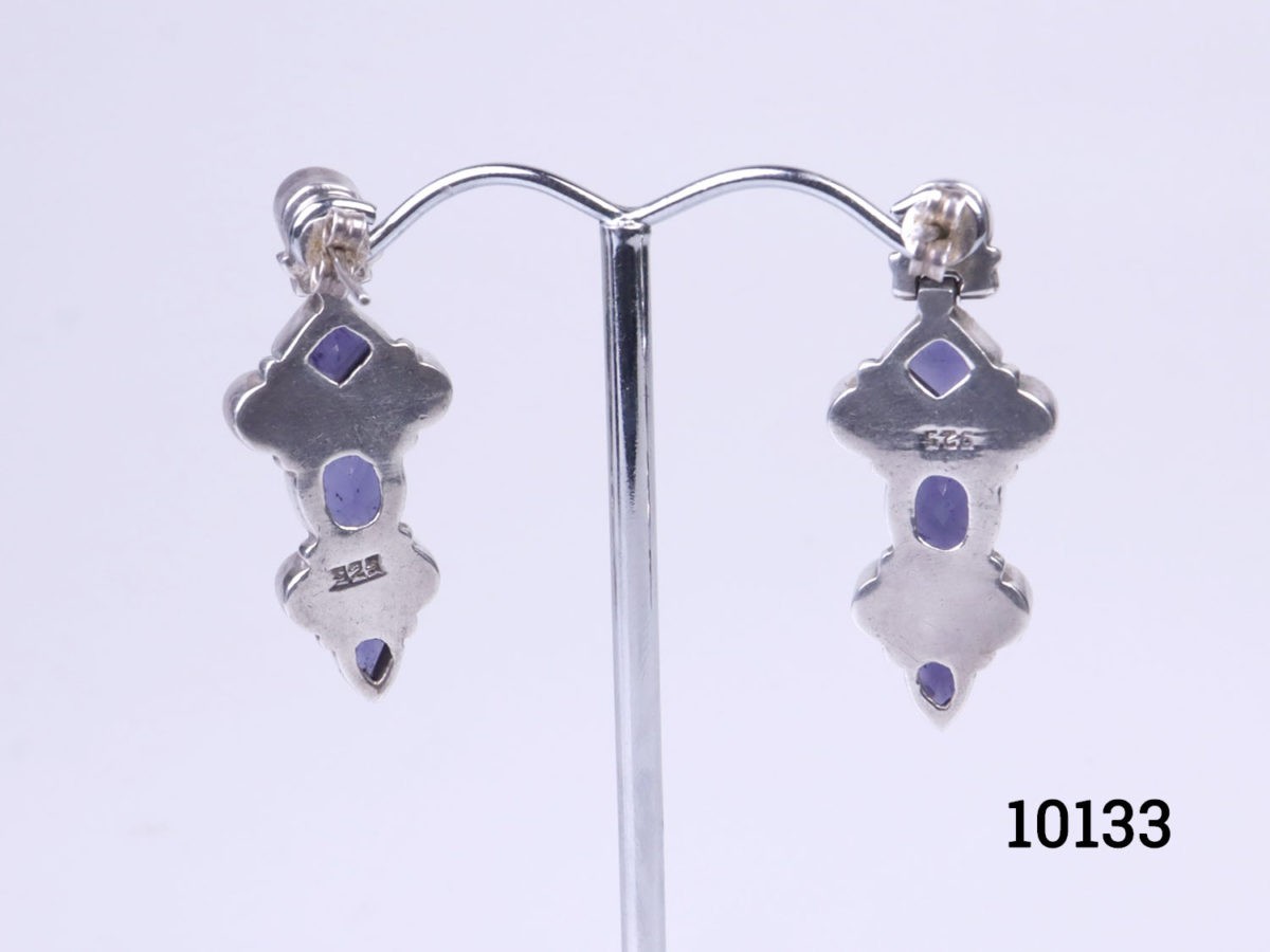 Vintage sterling silver earrings set with iolite stones. Various cuts of iolite stones set in 925 sterling silver. Hallmarked 925 to the back of earrings and butterflies. Each earring measures 36mm in drop length from top stud to base and 15mm at widest point.  Photo of both earrings on a display stand and shown with the back of earrings visible