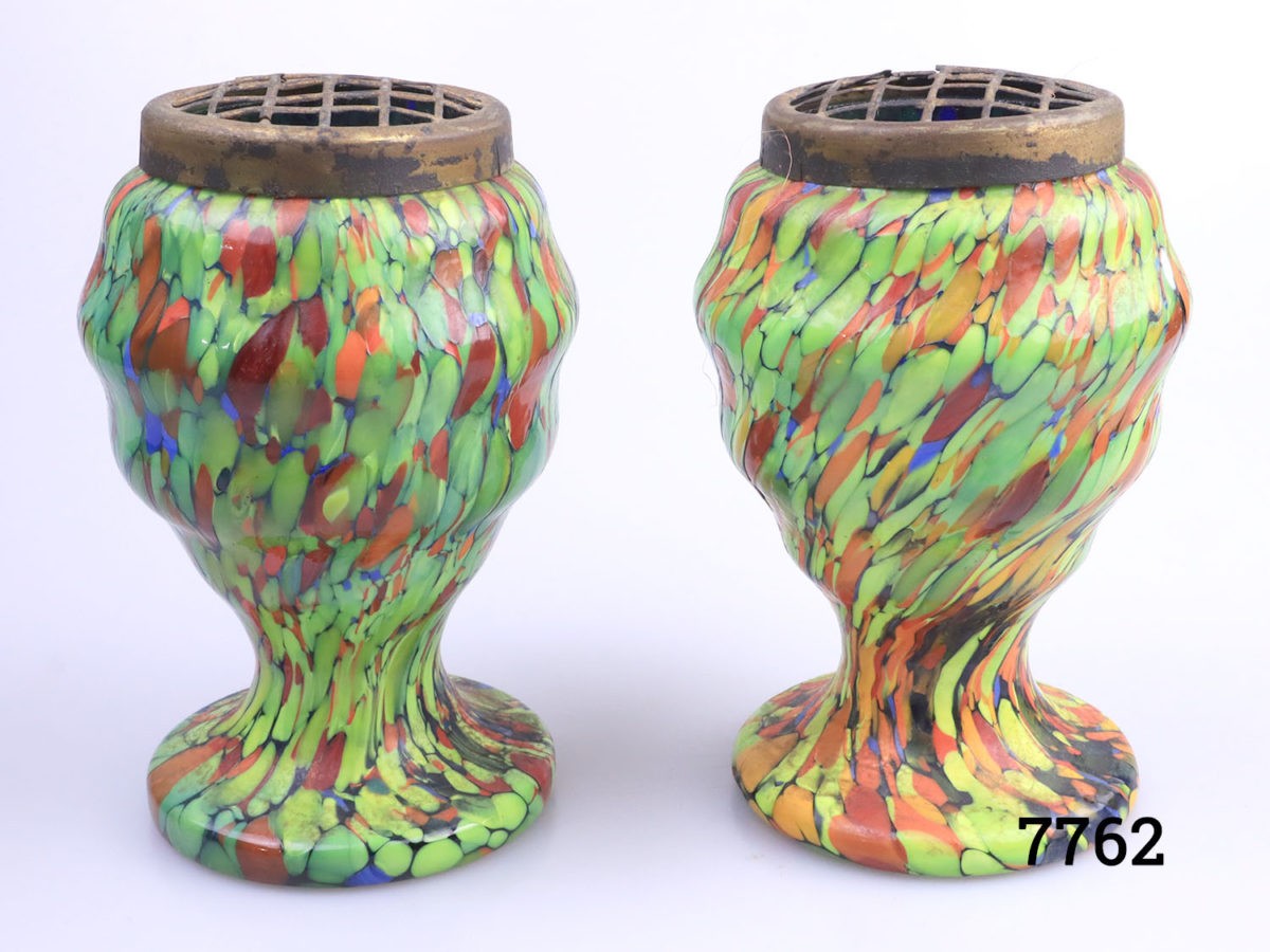 Pair of Art Deco splatter glass posy vases. Some damage to the brass frogs. Each measures 78mm in diameter at base, 90mm in diameter at widest area and 135mm tall.  Main photo of both vases side by side and seen from an eye level angle Photo of