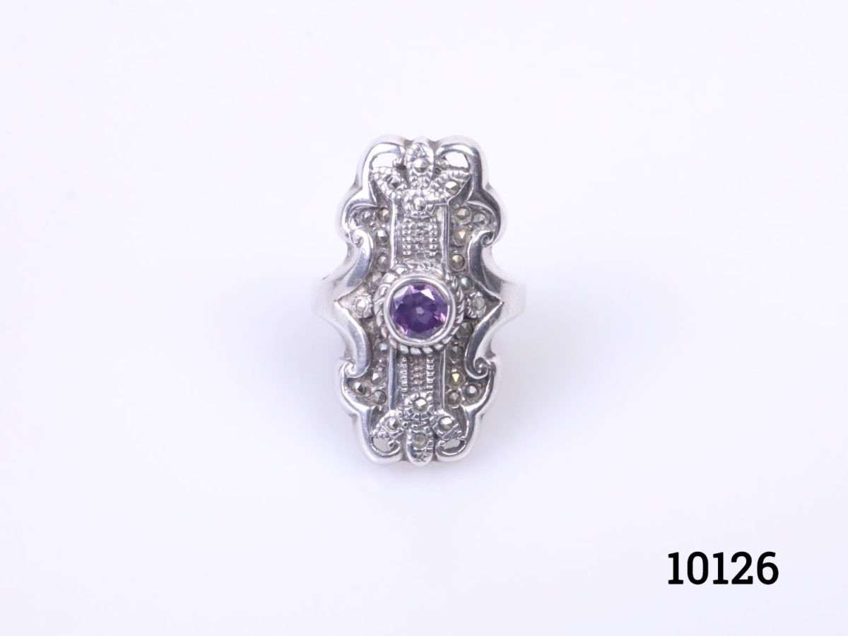 Vintage sterling silver ring set with a small amethyst coloured crystal stone to the centre. Hallmarked 925 on the back of ring front. Ring front measures 30mm by 15mm. Size P / 7.5 Photo of ring on a flat surface and seen from the front