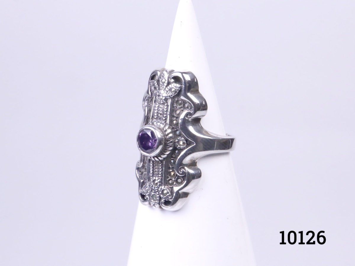 Vintage sterling silver ring set with a small amethyst coloured crystal stone to the centre. Hallmarked 925 on the back of ring front. Ring front measures 30mm by 15mm. Size P / 7.5 Photo of ring displayed on a cone shaped stand and seen from a slight side view