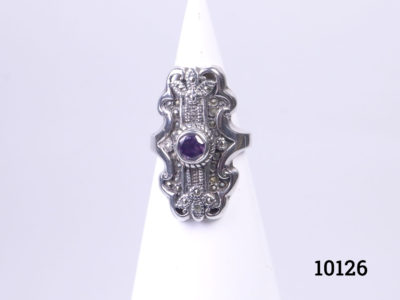Vintage sterling silver ring set with a small amethyst coloured crystal stone to the centre. Hallmarked 925 on the back of ring front. Ring front measures 30mm by 15mm. Size P / 7.5 Main photo of ring displayed on a cone shaped stand and seen from the front
