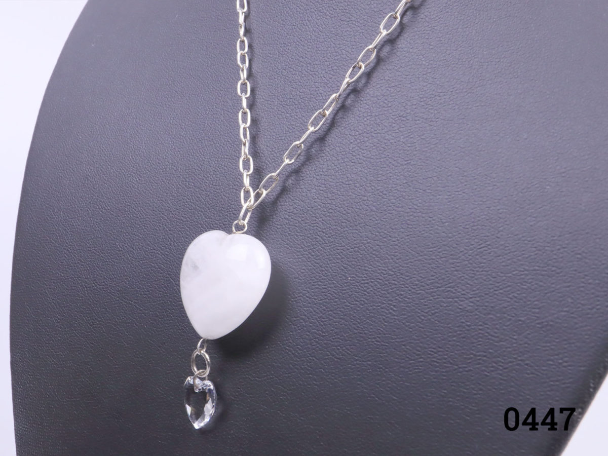 925 Sterling silver chain with a rock quartz crystal heart. A smaller clear crystal heart attached below the quartz heart. Pendant drop length 43mm. Close up photo of the crystal pendants seen from a side angle