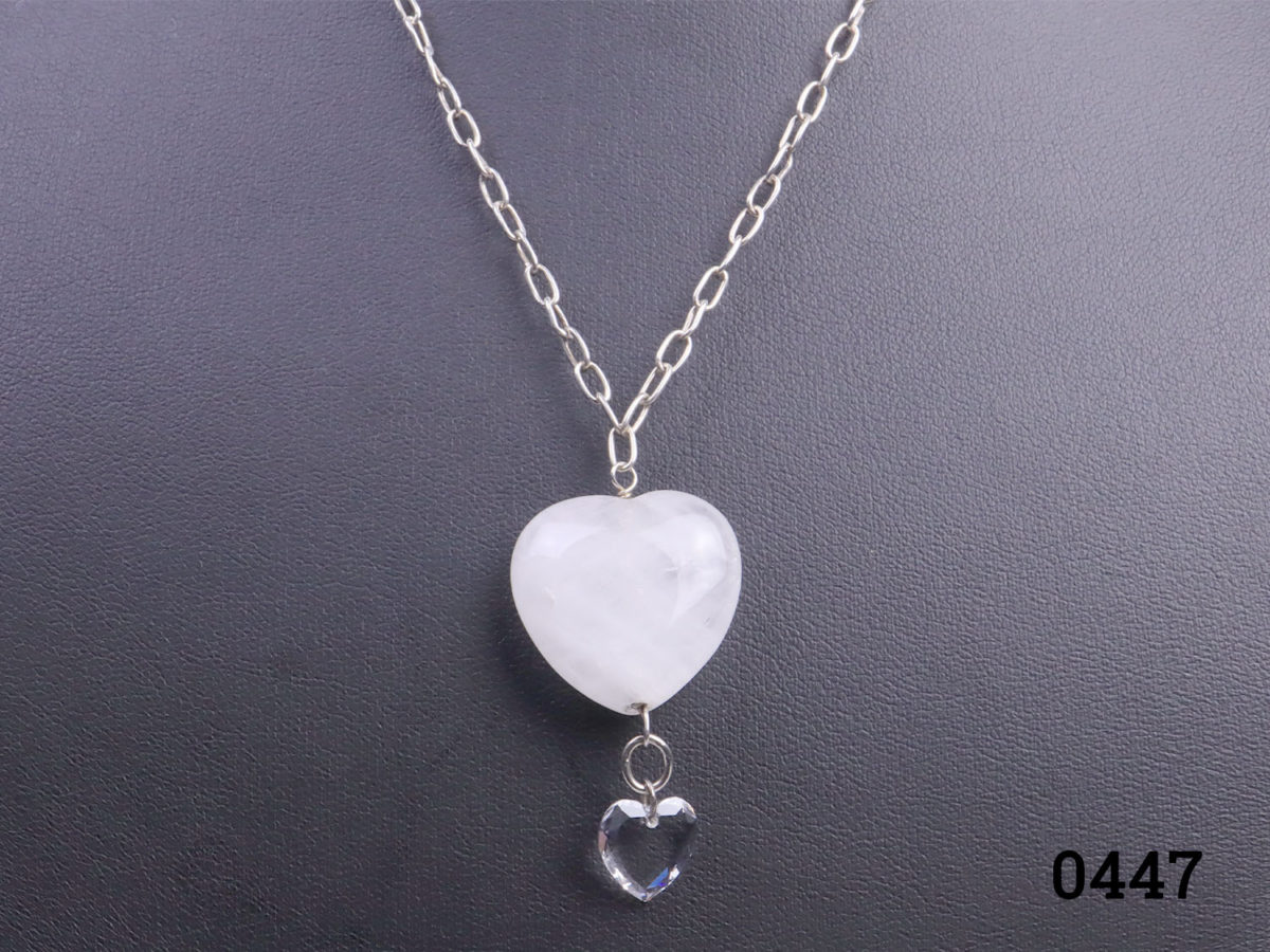 925 Sterling silver chain with a rock quartz crystal heart. A smaller clear crystal heart attached below the quartz heart. Pendant drop length 43mm. Close up photo of the crystal heart pendants seen from the front on