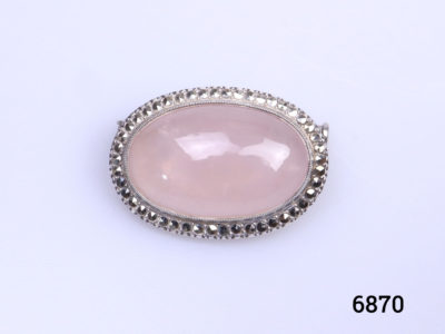 Sterling silver oval brooch set with rose quartz cabochon to the centre in a marcasite frame. Trombone clasp for added security. Main photo of brooch front