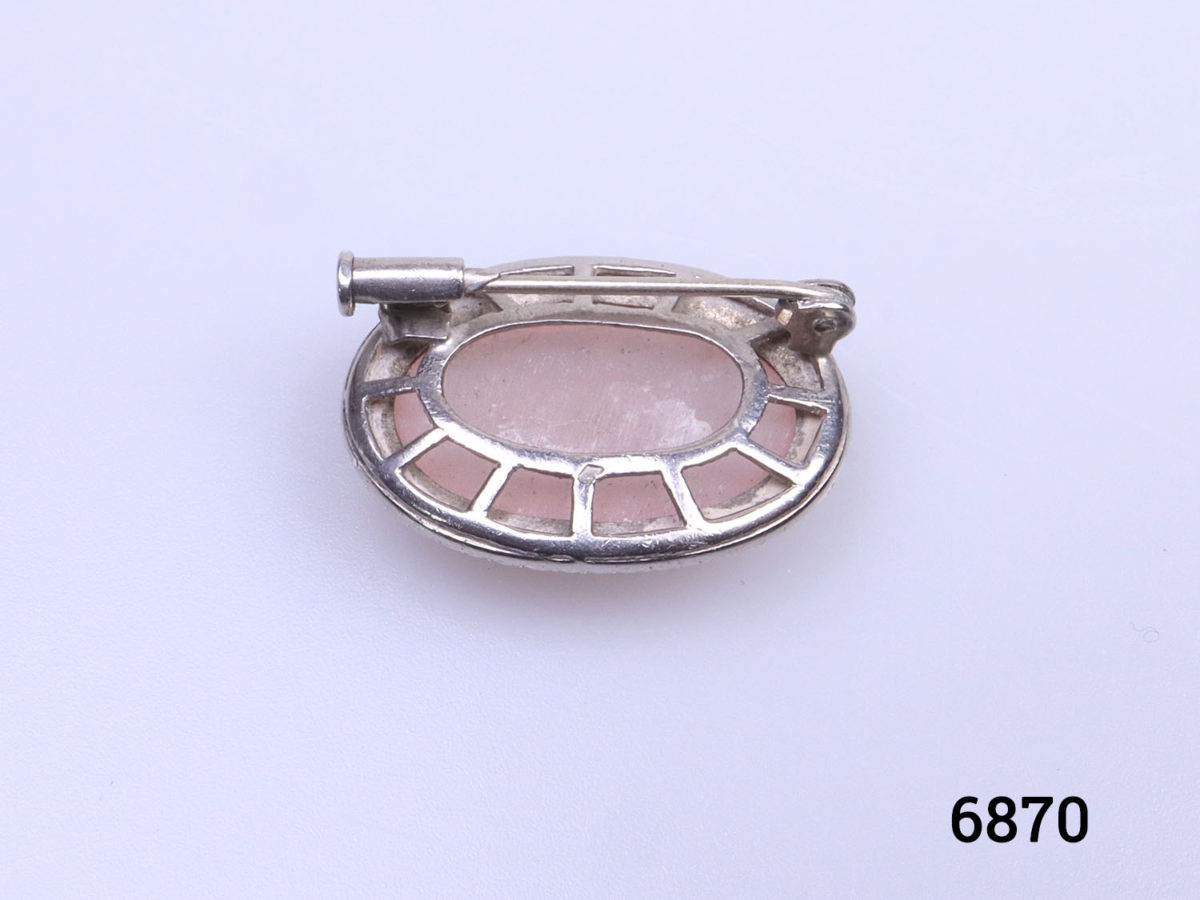 Sterling silver oval brooch set with rose quartz cabochon to the centre in a marcasite frame. Trombone clasp for added security. Photo of back of brooch