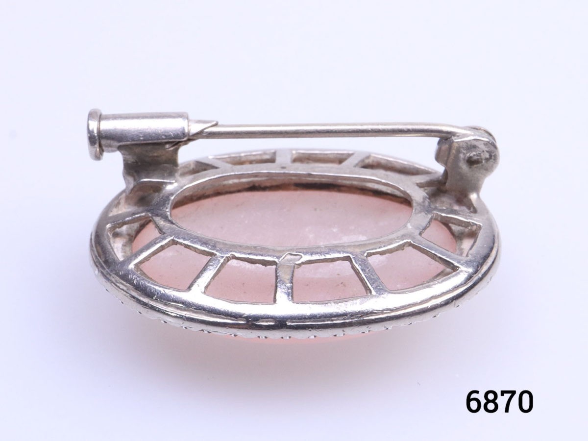 Sterling silver oval brooch set with rose quartz cabochon to the centre in a marcasite frame. Trombone clasp for added security. Close up photo of the brooch back with focus on the trombone clasp and brooch setting