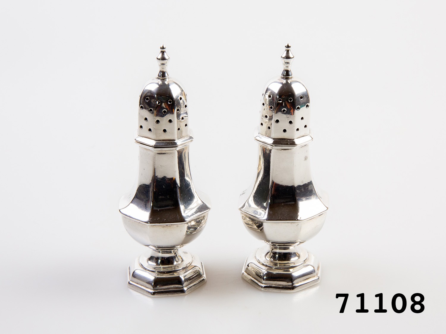 Antique pair of small sugar sifters. Each hallmarked to the side for Birmingham assay c1903 Made by Edward Souter Barnsley & Co. Some signs of wear. Each measures approximately 32mm in diameter at base and 92mm tall.  Main photo of both shakers standing side by side