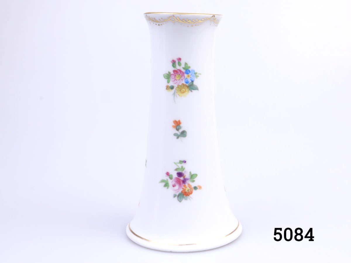 Antique pair of small Dresden vases. Short chimney shaped vases with iconic floral spray design finished with gilt trim to base and lip. Some minor signs of gilt wear and a hairline crack at the base of one vase. Measures 76mm in diameter at base and 50mm across the top. Photo of reverse side of one vase showing the lesser floral side