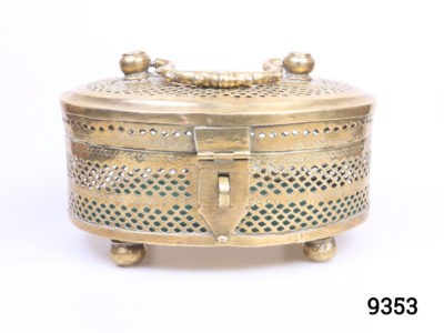 Vintage solid brass casket. Perforated solid brass casket on four round brass legs possibly used as a cricket cage or betel leaf storage case. Main photo of casket front with latch to the centre
