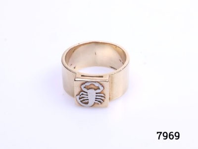 Birmingham assayed 9 karat gold ring set with a platinum scorpion to the front. Ring size approximately X / 11.5 Main photo of ring displayed on a flat surface with scorpion to the foreground