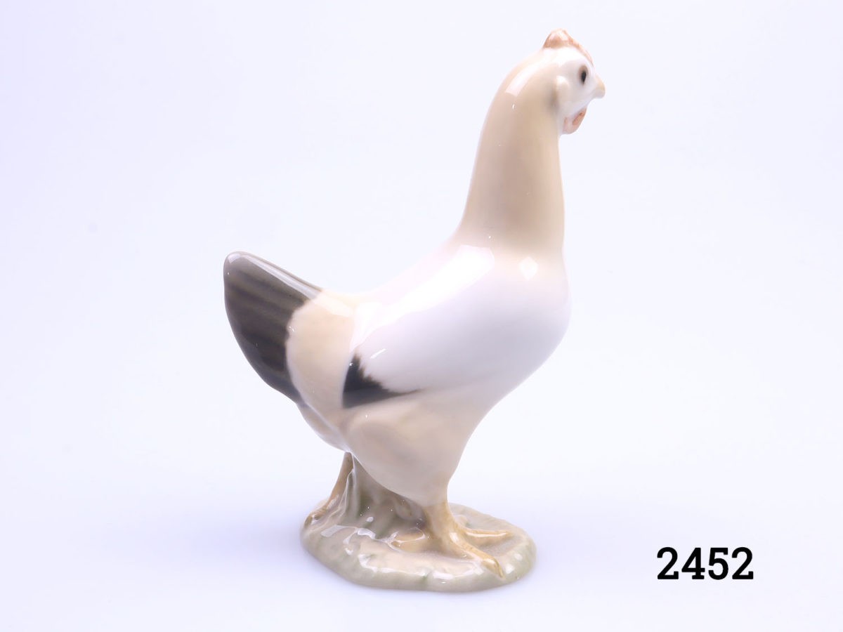 Vintage porcelain chicken made by Bing & Grondahl of Denmark. Small chicken ornament in earthy colours. Fully stamped to the base with the makers mark. Photo of chicken seen from other side angle with head facing away from camera