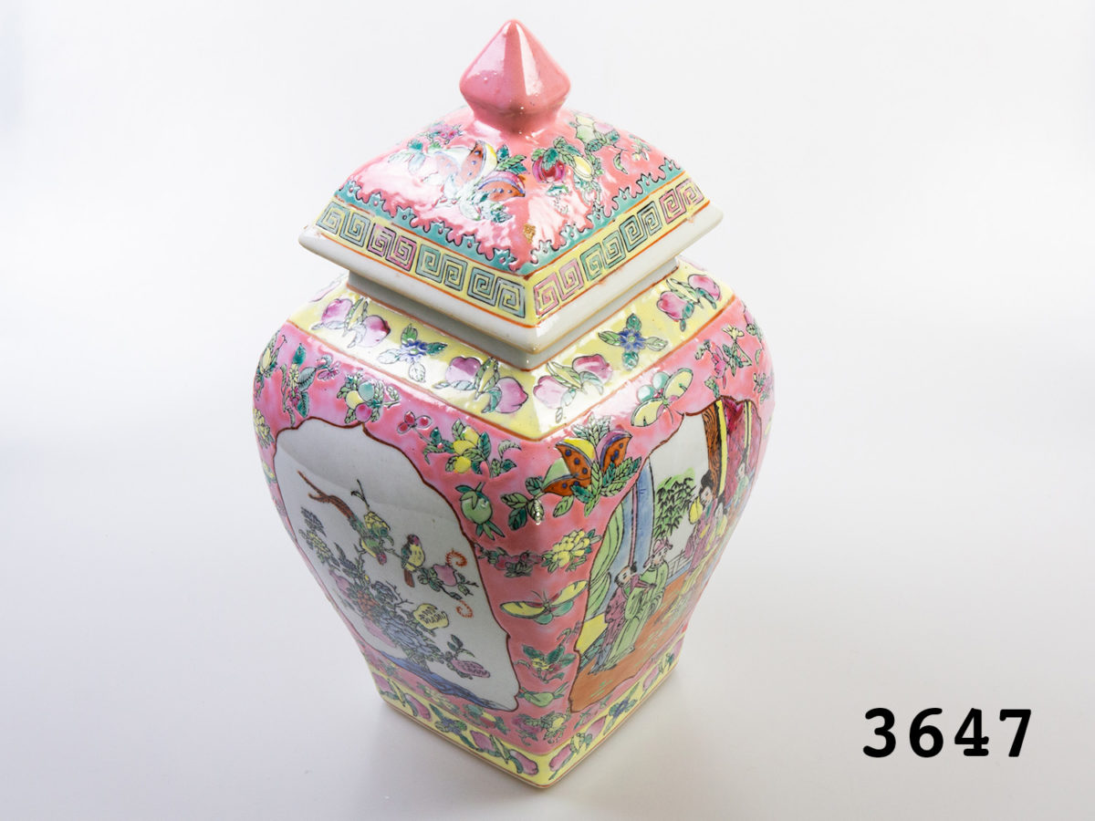 Vintage Chinese ginger jar. Unusual square based Famille Rose ginger jar with lid in mainly pink.Pictures to the sides alternating of Oriental figures or exotic birds and plants. Stamped to the base. Measures 95mm square at base and 170mm at widest point. Photo of jar seen from a raised diagonal angle showing the 2 decorative sides and the detail on the lid