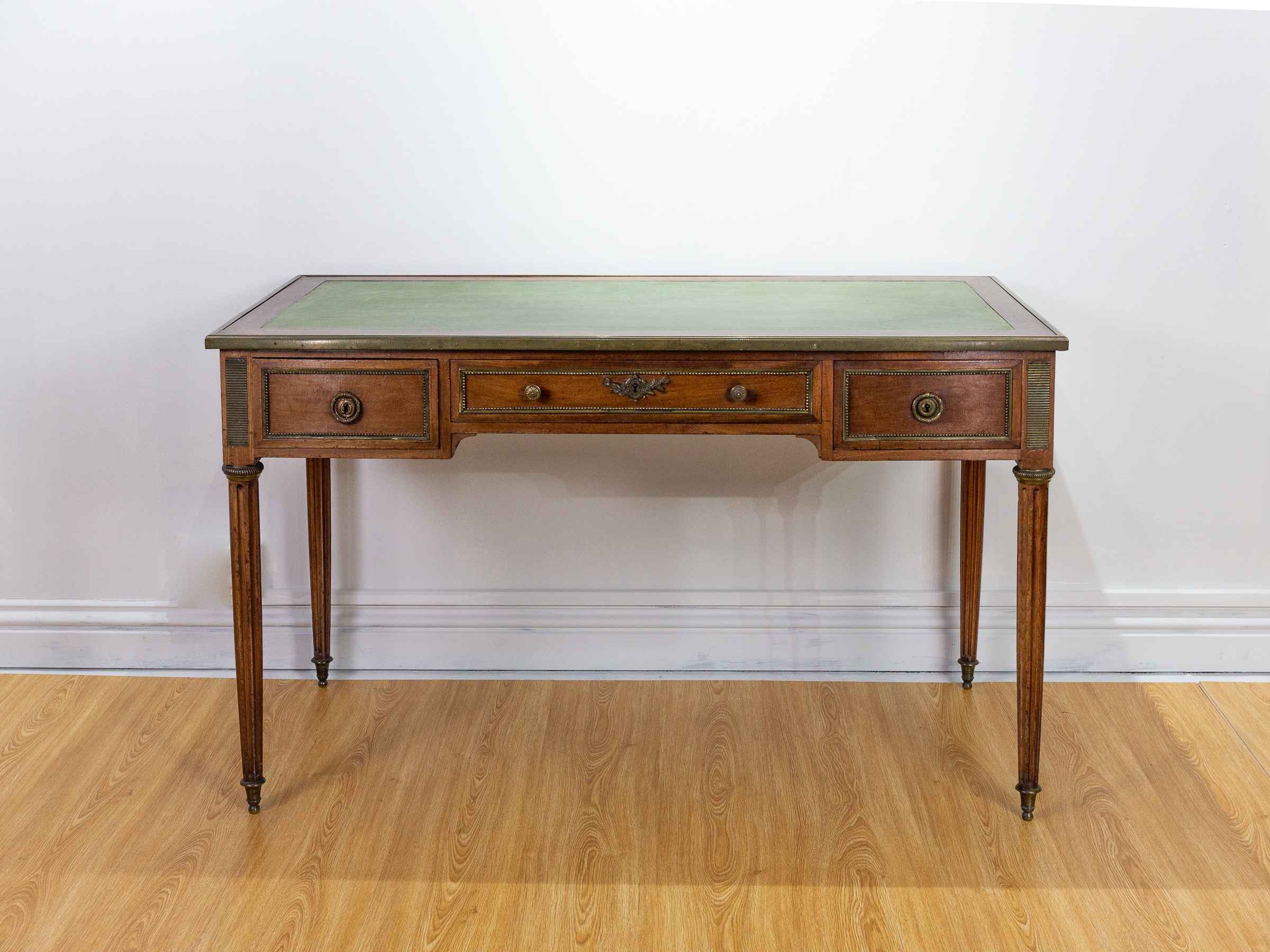 19th Century French bureau. Antique mahogany bureau with green leather top and bronze inlay trim and 3 drawers. In excellent condition.