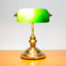 Vintage style bankers lamp with brass base and body and an iconic green glass shade. Position of shade can be adjusted by turning. The base measures approximately 175mm in diameter. Shade measures 215mm wide by 130mm deep at widest point.