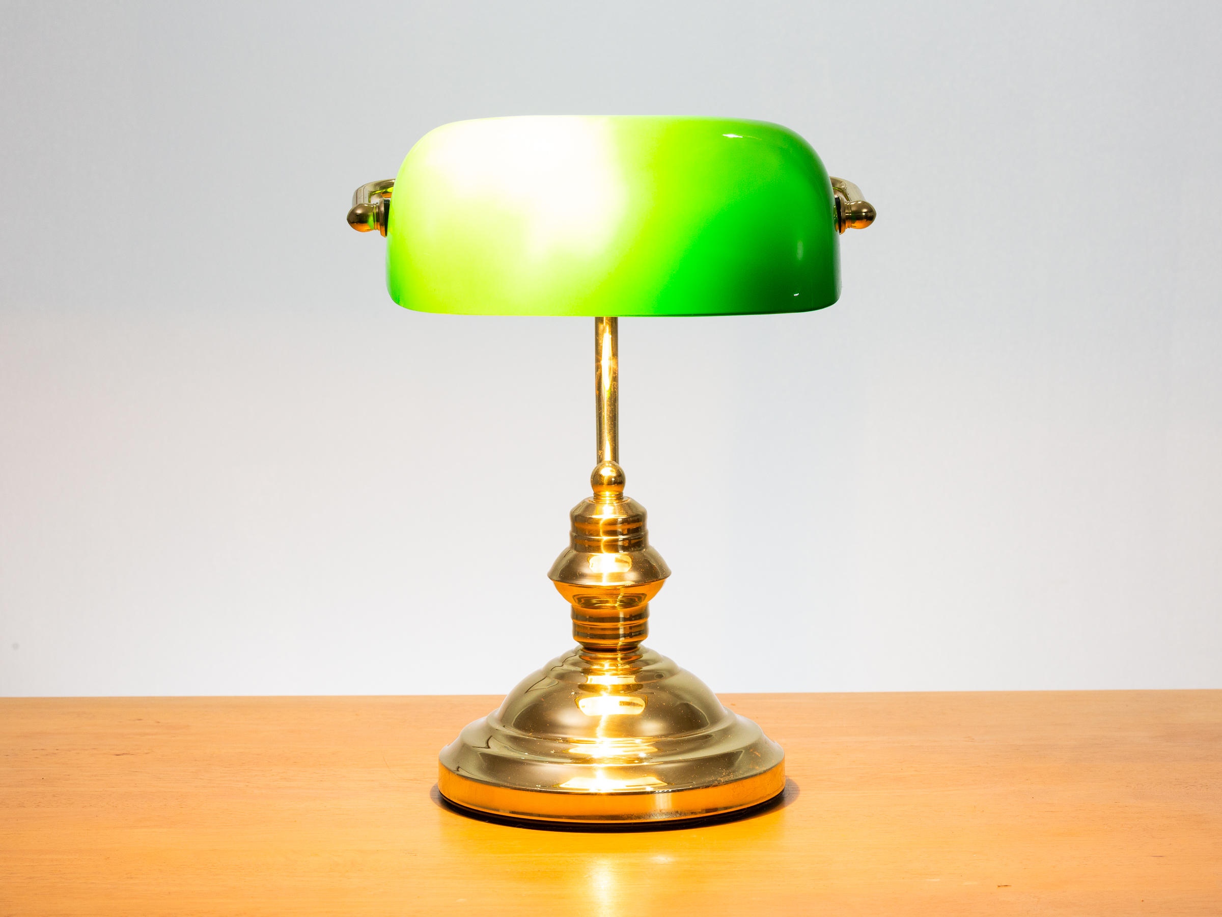 Vintage style bankers lamp with brass base and body and an iconic green glass shade. Position of shade can be adjusted by turning. The base measures approximately 175mm in diameter. Shade measures 215mm wide by 130mm deep at widest point.