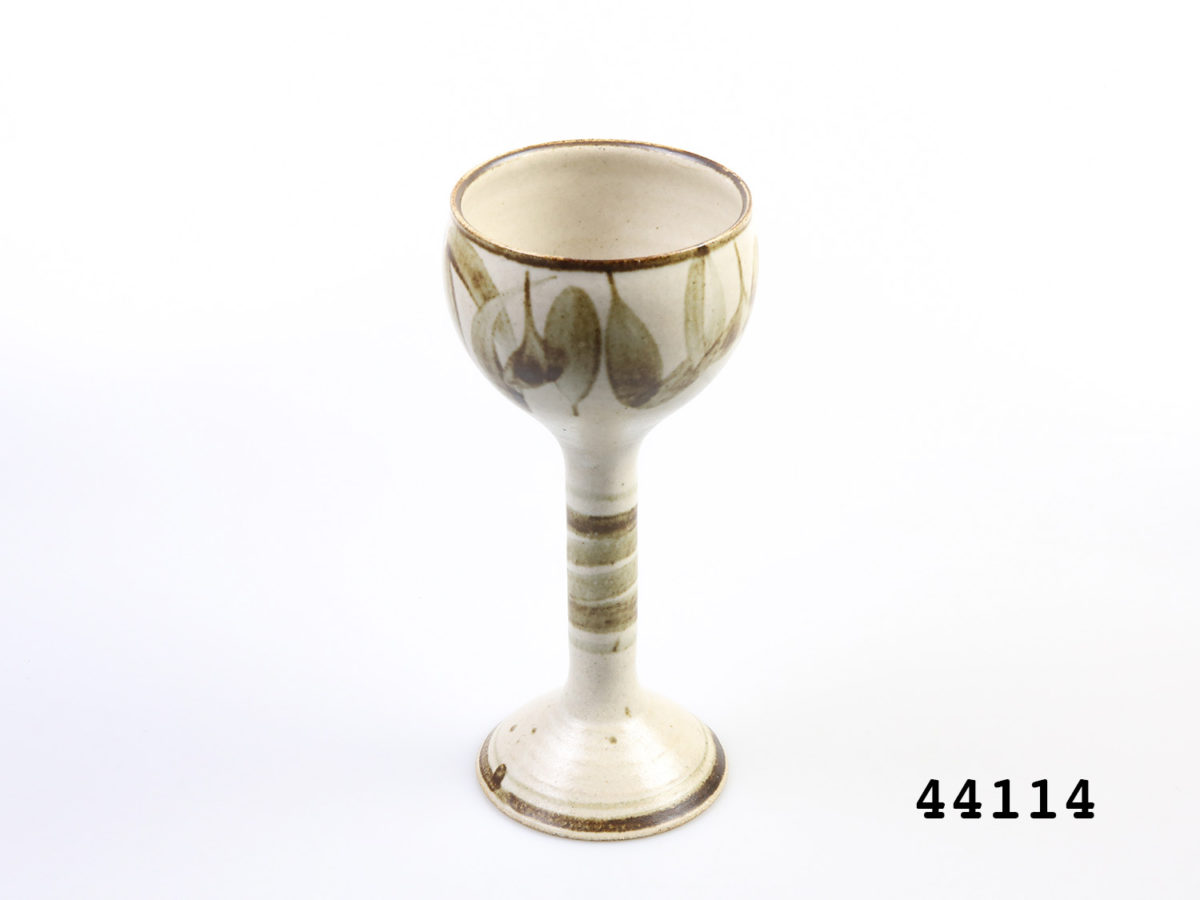 c1960s vintage German Studio Pottery goblets. Pair of tall goblets in earthy colours and design. Each goblet measures approximately 88mm in diameter at base and 95mm in diameter across the mouth. Photo of one goblet from a slight raised angle.