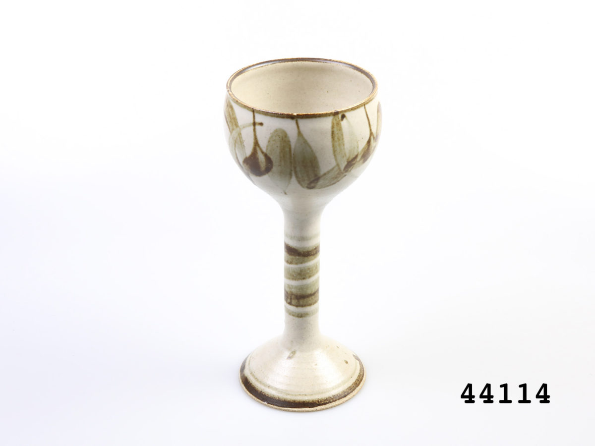 c1960s vintage German Studio Pottery goblets. Pair of tall goblets in earthy colours and design. Each goblet measures approximately 88mm in diameter at base and 95mm in diameter across the mouth. Photo of one goblet seen from a slightly raised angle.
