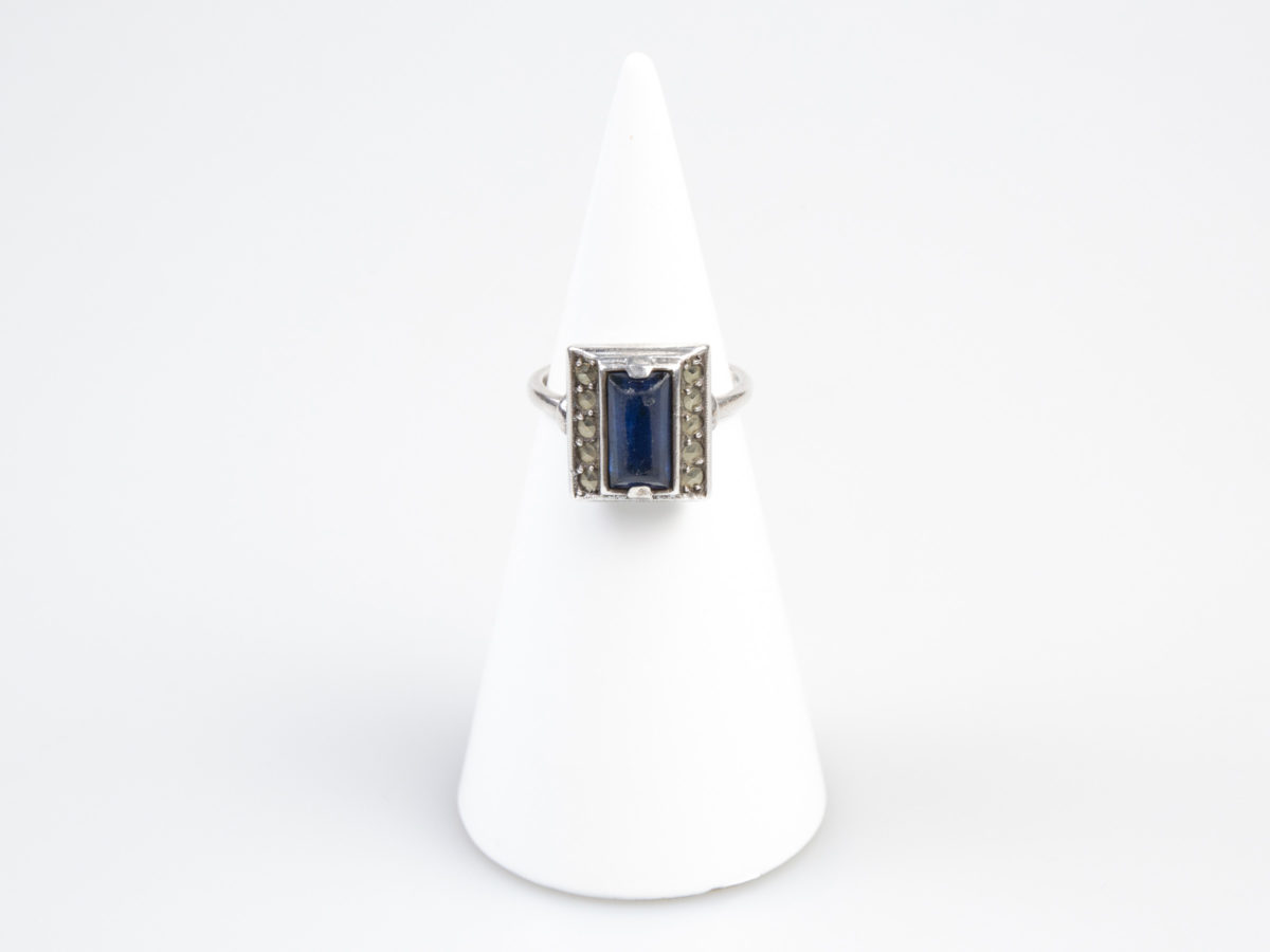 Vintage Art Deco style ring. Hallmarked 935 silver ring with a rectangular cut royal blue glass stone to the centre. Ring size M.5 / 6.5 Main photo of ring displayed on a cone display stand with ring front facing forward