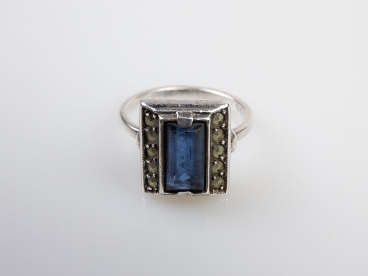 Vintage Art Deco style ring. Hallmarked 935 silver ring with a rectangular cut royal blue glass stone to the centre. Ring size M.5 / 6.5 Photo of ring on a flat surface and seen with ring front facing forward