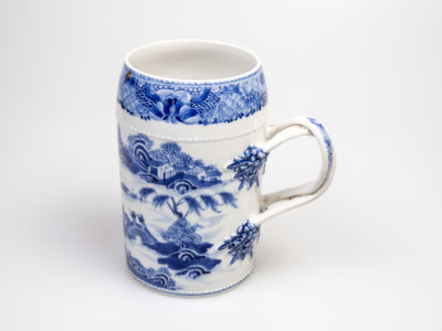 Antique Chinese blue and white tall mug. Rare mug from the Qianlong Li era c1736-1795. Decorated in classic willow pattern with an intricate and unusual 2 pleat handle. Small chip of the paint on the outer pleat handle and what appears to be a crack but most likely a consequence of the manufacturing process on the top of the inner pleat handle.  Otherwise in excellent condition for its age. Measures 82mm in diameter at base, 72mm across the top and 130mm at widest. Main photo of the mug showing the water side with the junk boat and bridge. Also the intricate design work on the handle ends