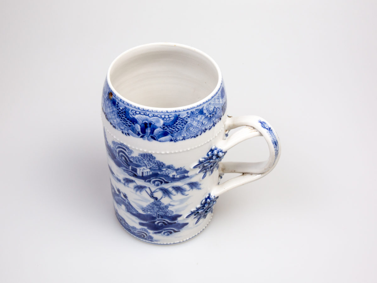 Antique Chinese blue and white tall mug. Rare mug from the Qianlong Li era c1736-1795. Decorated in classic willow pattern with an intricate and unusual 2 pleat handle. Small chip of the paint on the outer pleat handle and what appears to be a crack but most likely a consequence of the manufacturing process on the top of the inner pleat handle.  Otherwise in excellent condition for its age. Measures 82mm in diameter at base, 72mm across the top and 130mm at widest. Photo of muf seen from a little height just showing the interior of the mug The handle is shown to the right