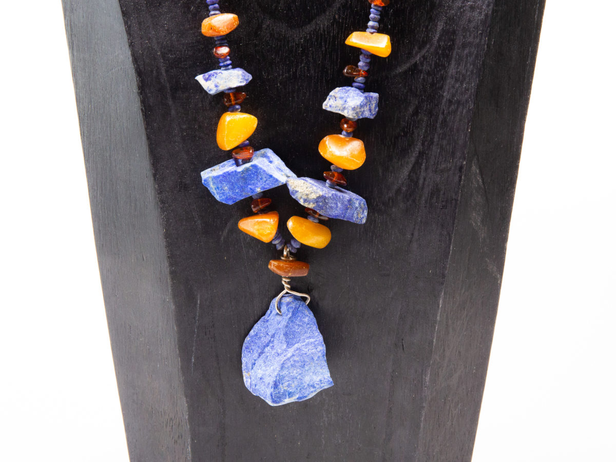 Natural amber and lapis stone necklace. Untreated natural lapis lazuli and amber bead necklace. Chunky beads put together in an indigenous style and separated with natural small lapis beads. an unusual & quite unique statement necklace. Large lapis stone at the front measures 35mm long and 32mm wide at the bottom. Close up photo of the front end of neckace