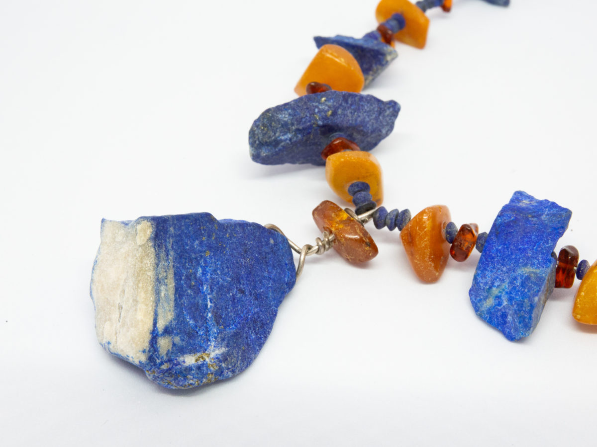 Natural amber and lapis stone necklace. Untreated natural lapis lazuli and amber bead necklace. Chunky beads put together in an indigenous style and separated with natural small lapis beads. an unusual & quite unique statement necklace. Large lapis stone at the front measures 35mm long and 32mm wide at the bottom. Close up photo of the large natural lapis lazuli stone at the front of the necklace